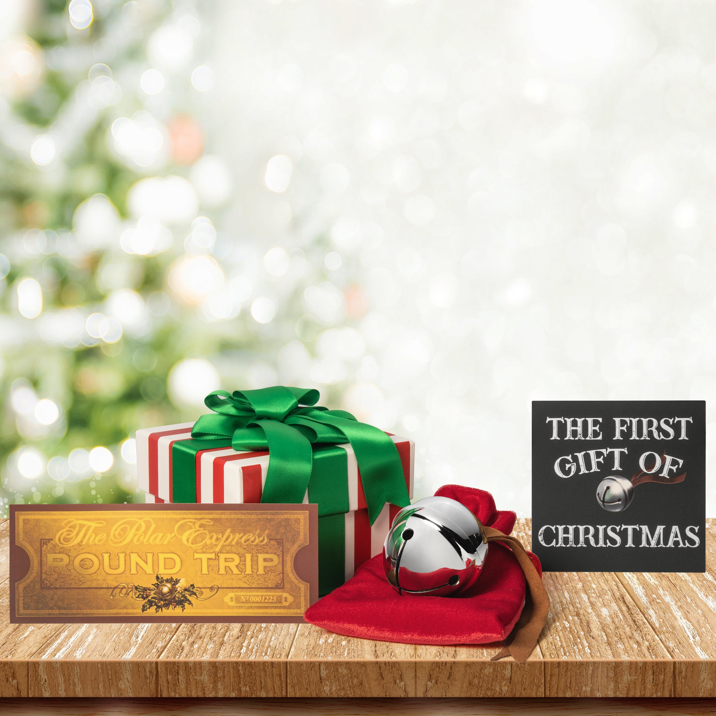 Christmas-themed items including a gift box, Polar Express sleigh bell, and 'Round Trip' ticket on a wooden surface with a blurred Christmas tree in the background.